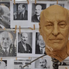 Clay state sculpture of CLEMENT ATTLEE at the Artist’s Studio. In the background, reference material is visible for the artist to do his work.