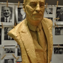 Clay state portrait sculpture of CLEMENT ATTLEE at the Artist’s Studio. Reference photographs of Attlee are in the background.
