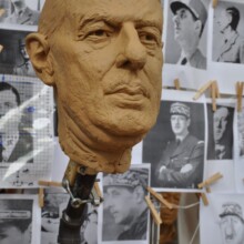 Clay state sculpture of CHARLES DEGAUL at the Artist’s Studio. Reference photos are in the background for the artist to capture DeGaul's likeness.