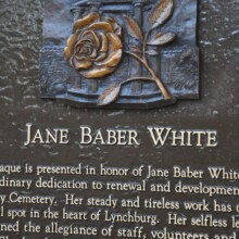 The memorial plaque for JANE BARBER WHITE in its final bronze state. The plaque resides at Old City Cemetery in Lynchburg, VA. The plaque depicts a beautiful rose with its leaves and stem.