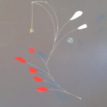 This mobile by Richard Pumphrey is titled "POINT-COUNTERPOINT." It features aluminum, stone, and paint materials.