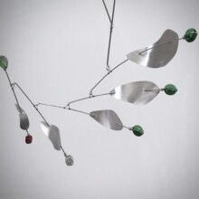 This image features a detail view of the mobile by Richard Pumphrey titled "CLEFF." The artist employed the use of aluminum and glass materials.