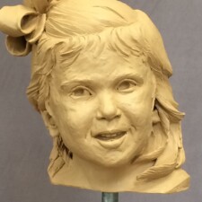 Commissioned portrait sculpture of child named SCARLETT. This image portrays the sculpture in-progress and in its clay state.
