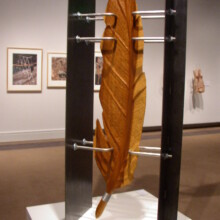 Woodcarving by Richard Pumphrey titled "COMPROMISED VII," materials used: wood, stainless steel, and steel.